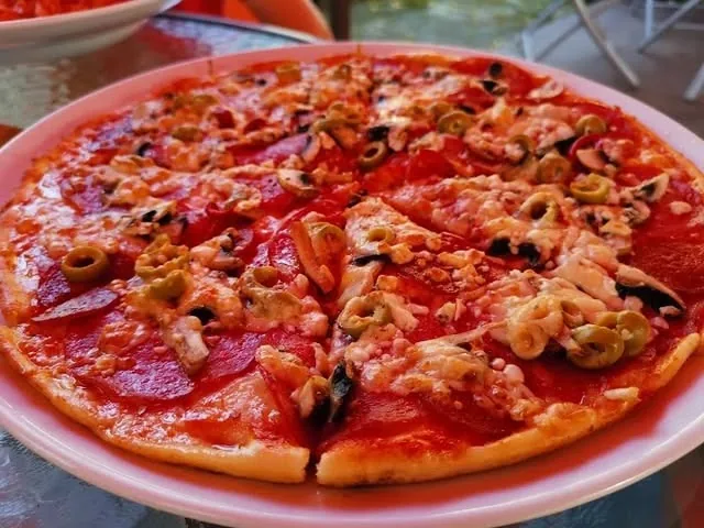 Pizza so salámou, olivami a šampiňónmi na tanieri